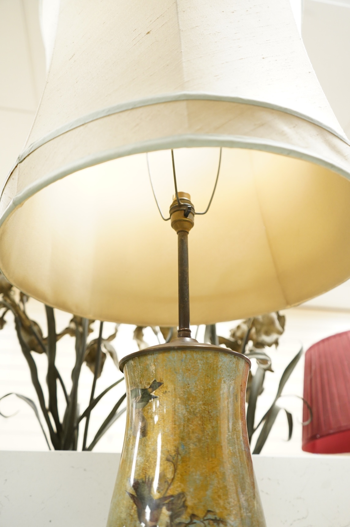 A pair of table lamps and shades, 92cm high, the lamps decorated in gold and green tones painted with birds and flowers, together with a small glass and brass hall lantern (3).